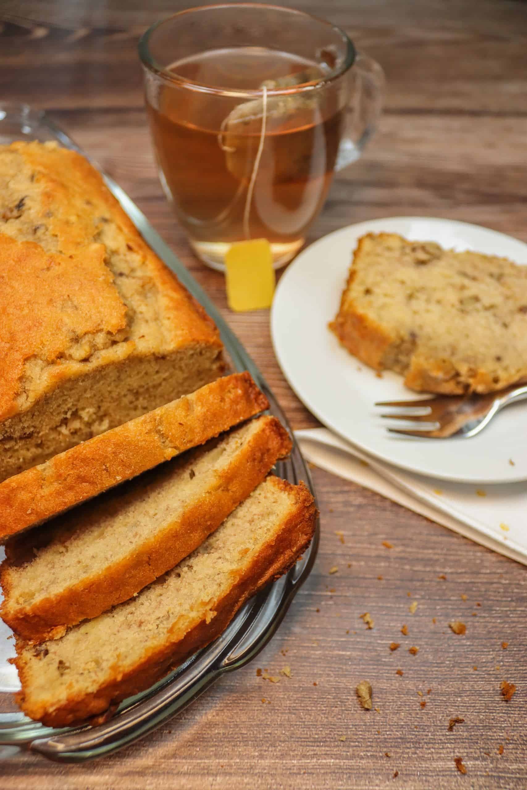 Bananenbrot mit Walnüssen auf einem Teller und dazu Tee