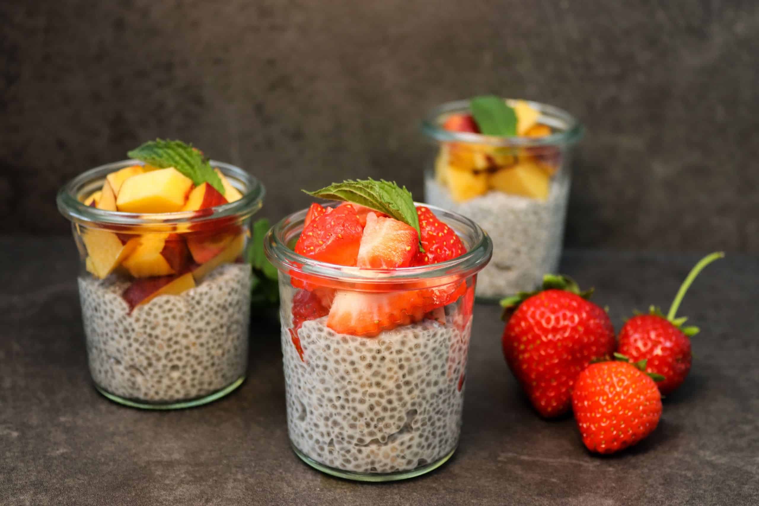 Leckerer Chiapudding mit Erdbeeren und Pfirsichen in einem Gläschen