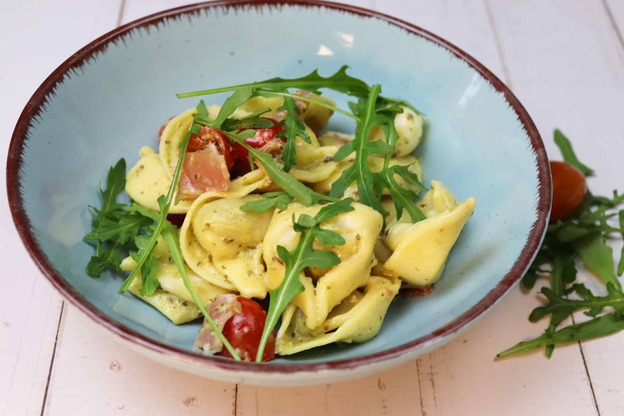 Tortellinisalat mit Rucola, Tomaten und Mozzarella in einer Schüssel