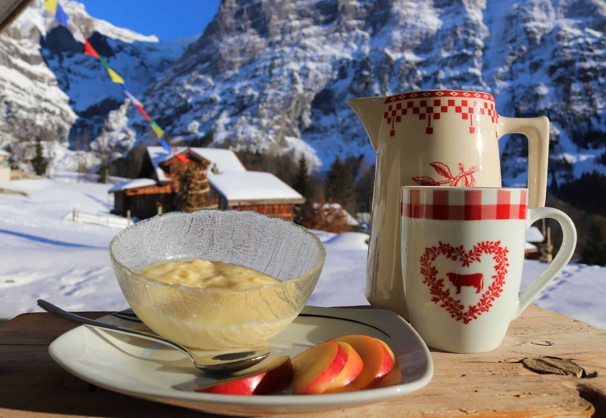 Milchreis mit Apfel und zwei Kännchen in den Bergen