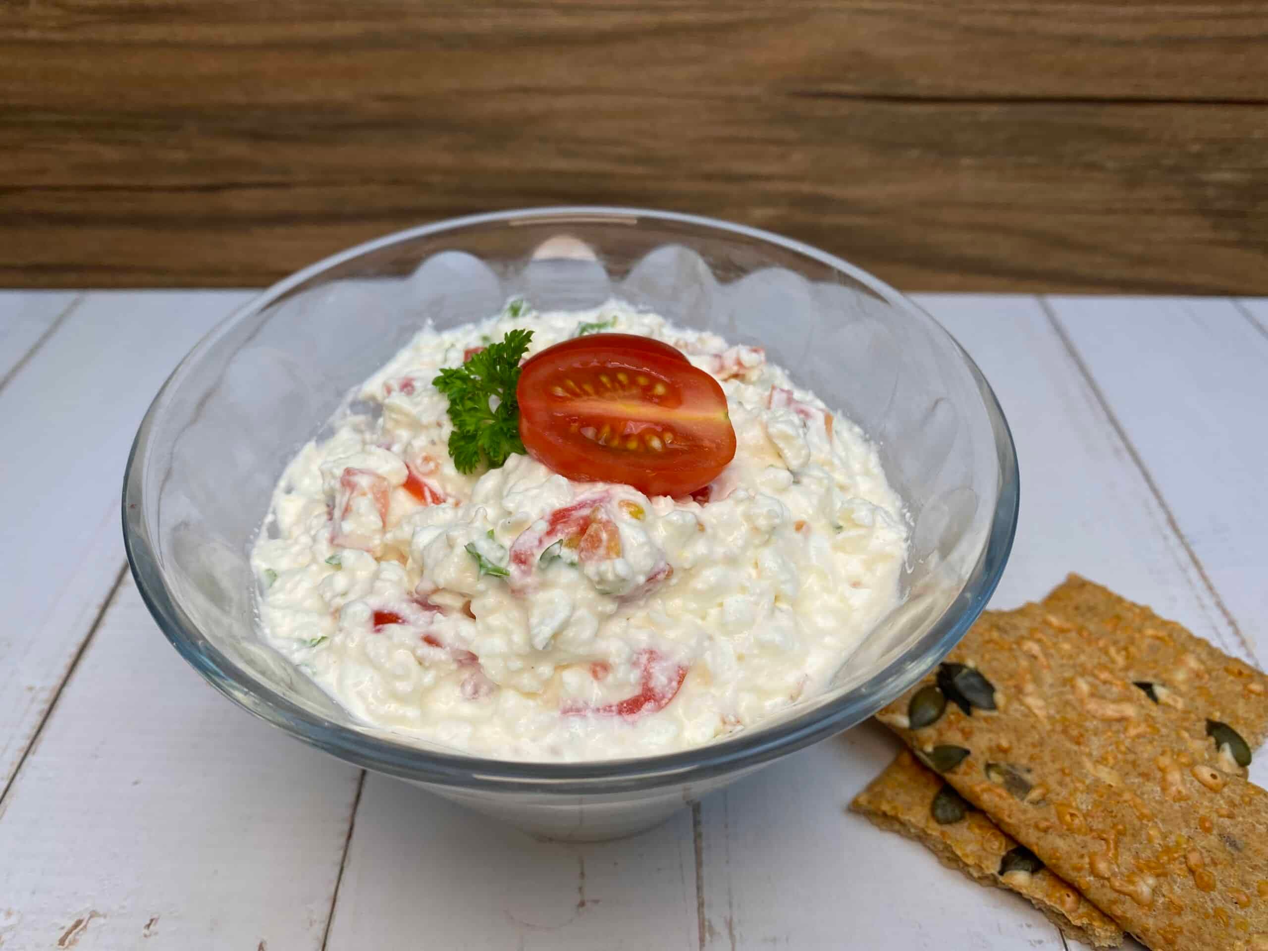 Leckerer Hüttenkäse-Tomaten-Dip in einer Schale mit Knäckebrot