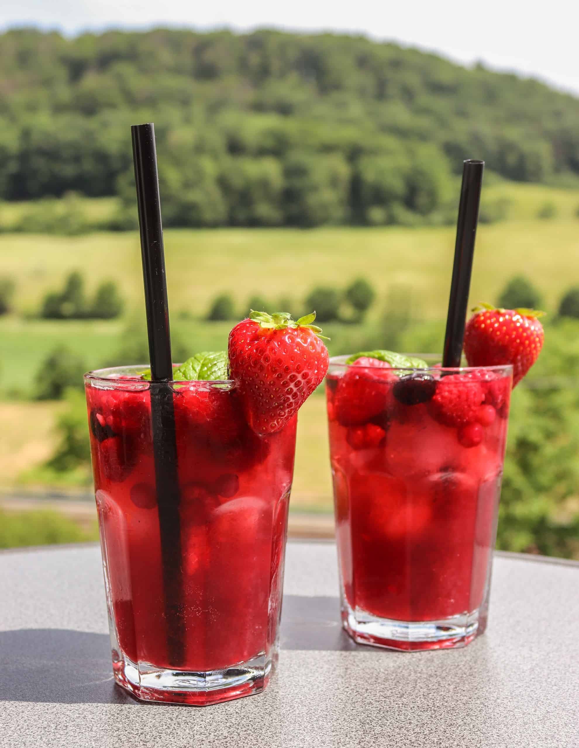 Zwei erfrischende Gläser Sommerliche Bowle auf einem Tisch im freien.