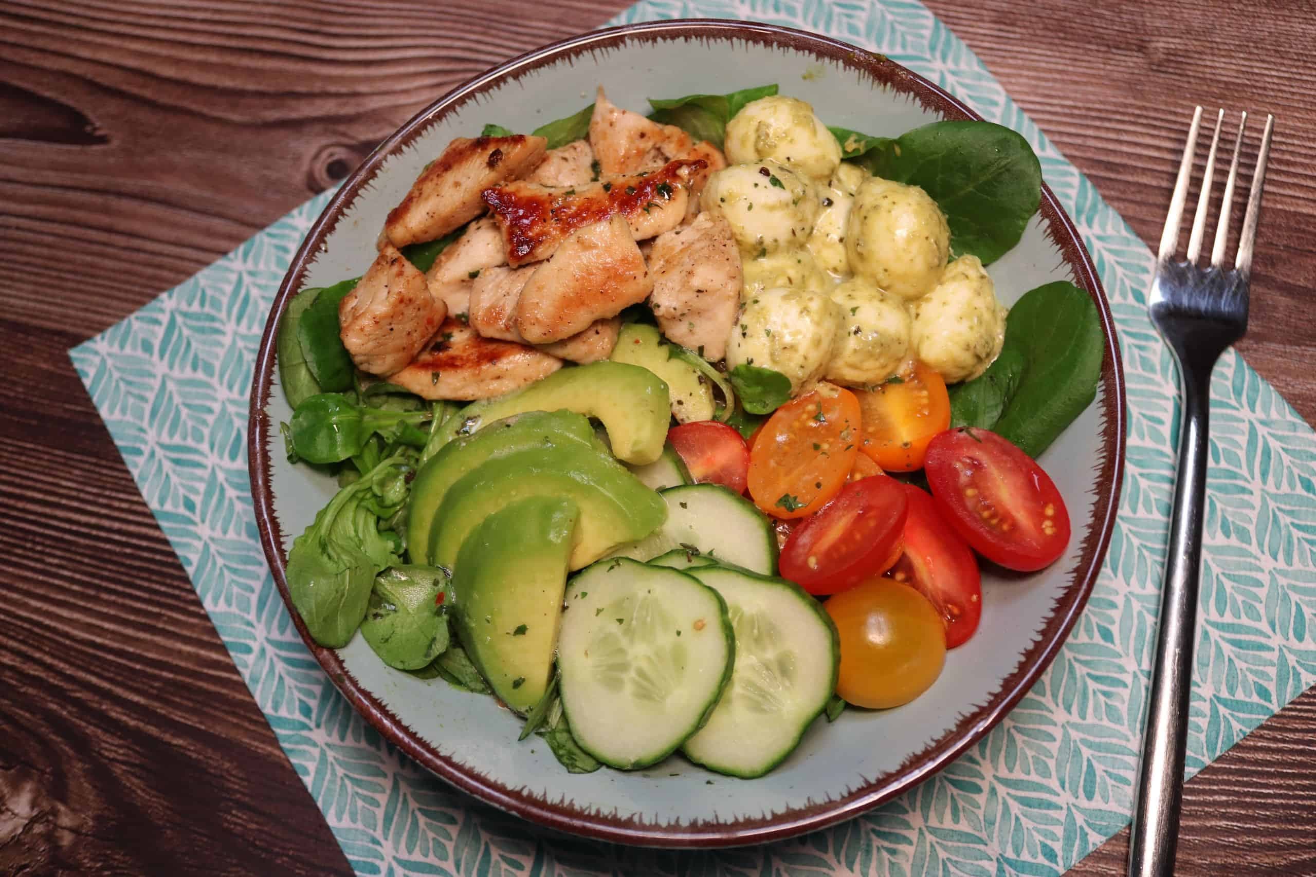 Buddha-Bowl mit Salat und Hähnchen in einer Schüssel.