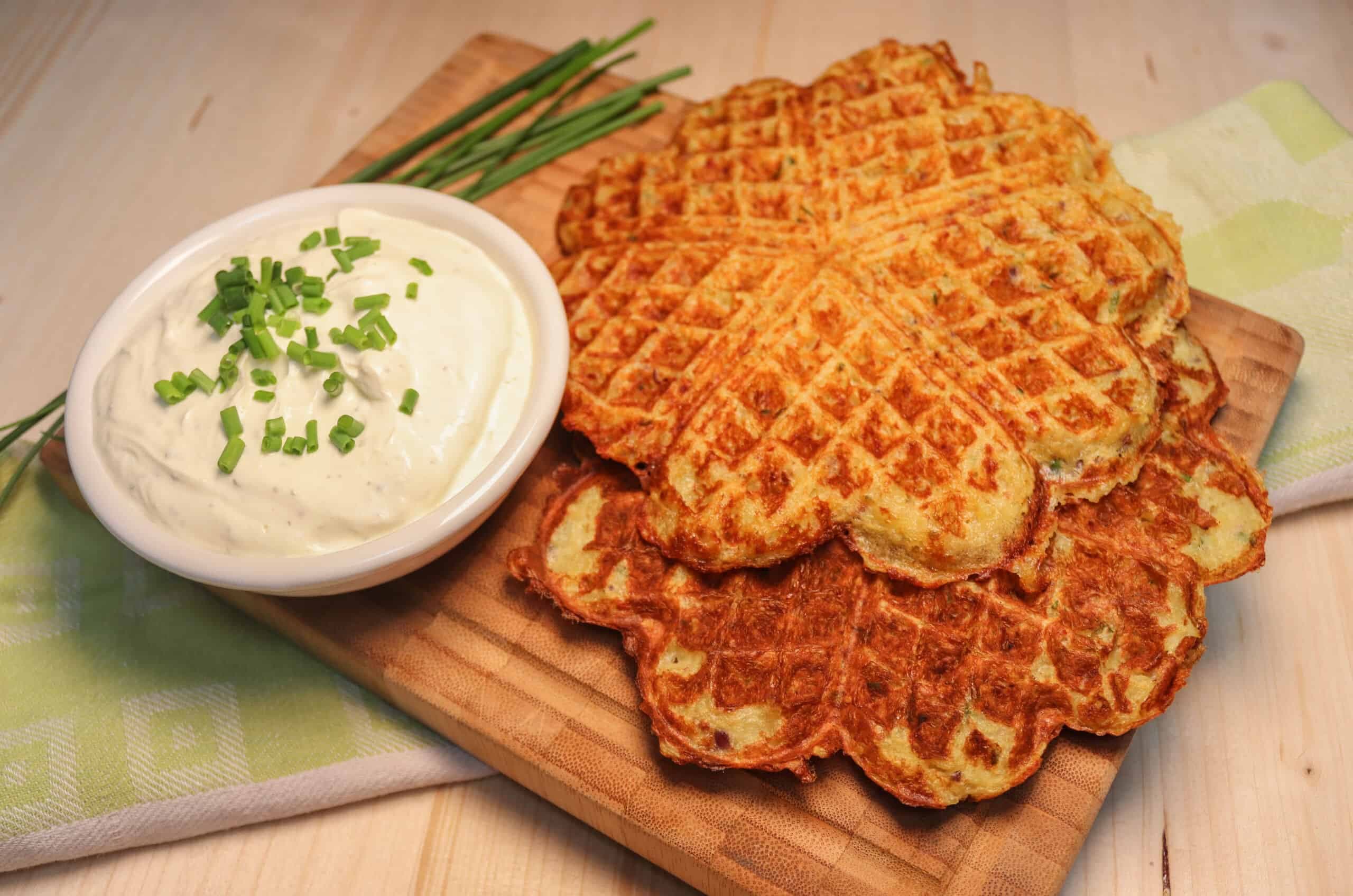 Leckere Kartoffelwaffeln mit Sour cream auf einem Brettchen