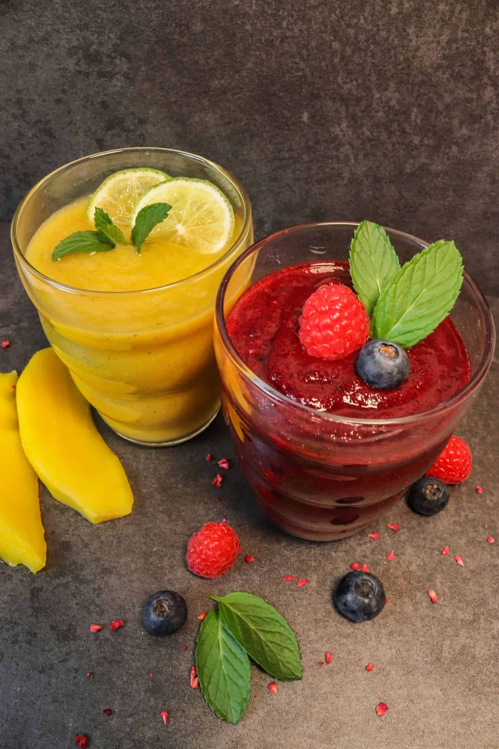 Leckere Smoothies, entweder ein roter Beerensmoothie oder ein gelber Sommersmoothie, mit verschiedenem Obst