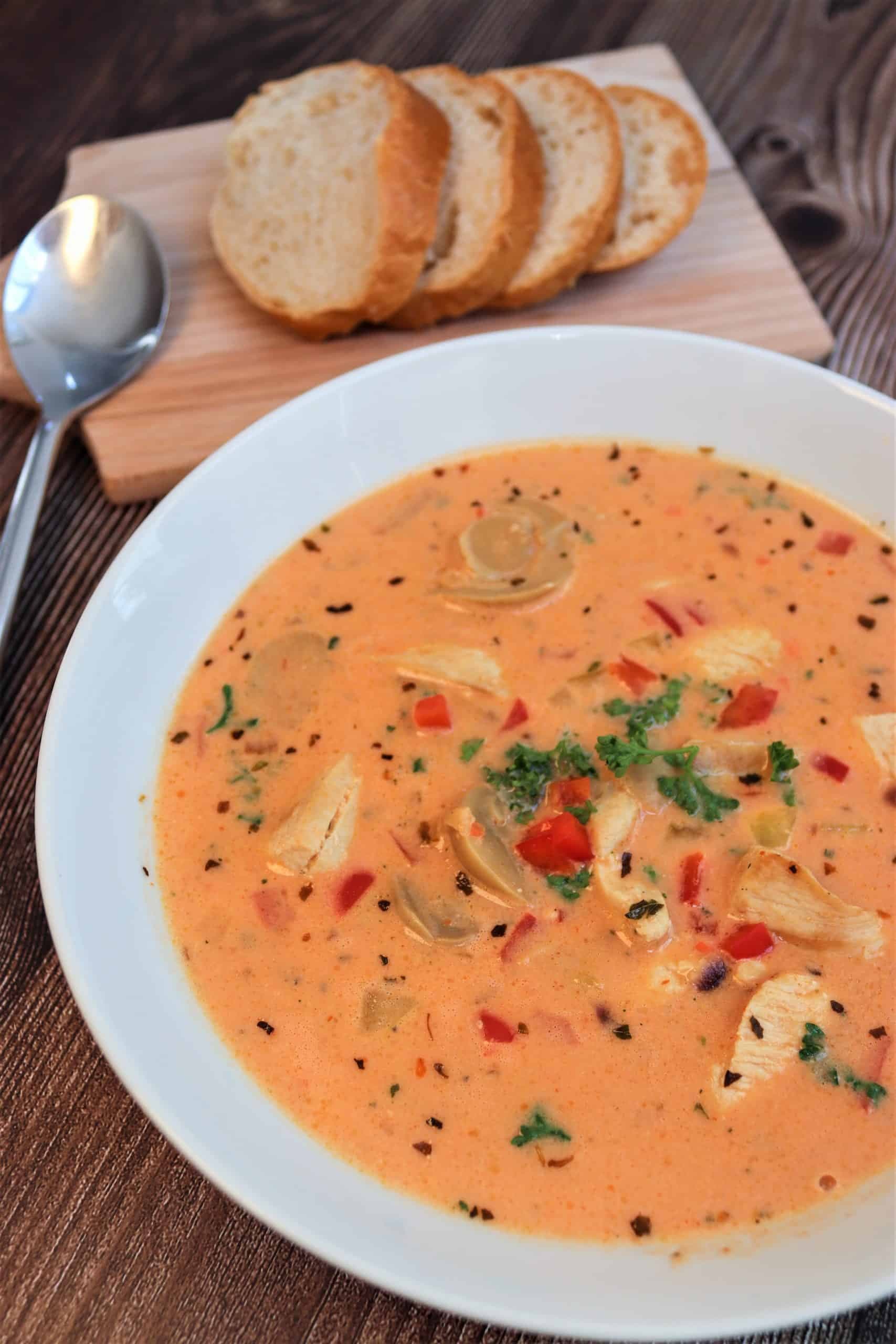 Leckere mediterrane Suppe in einer Schüssel mi Kräutern und Brot